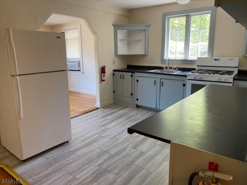 13 Bridge Street Stockton, NJ 08559 - Photo 5 of 11 a kitchen with stainless steel appliances granite countertop a refrigerator a sink dishwasher a stove with wooden floors