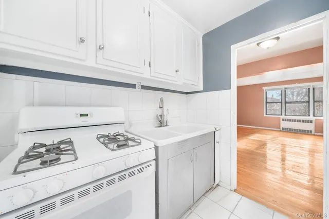 a kitchen with granite countertop a sink stove and cabinets