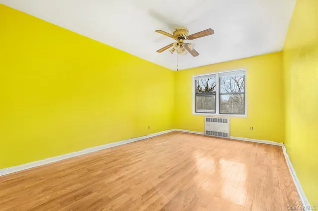a view of a big room with wooden floor and windows