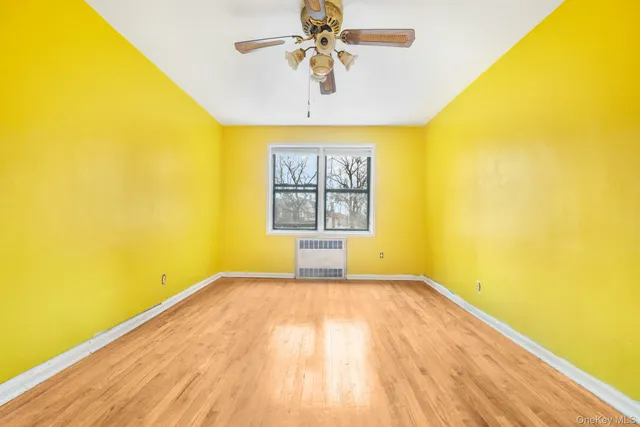 a view of a big room with windows and chandelier fan