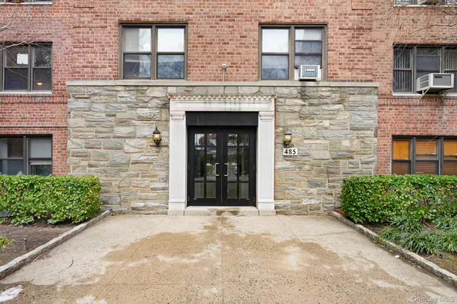 a front view of a brick building with a door and a window