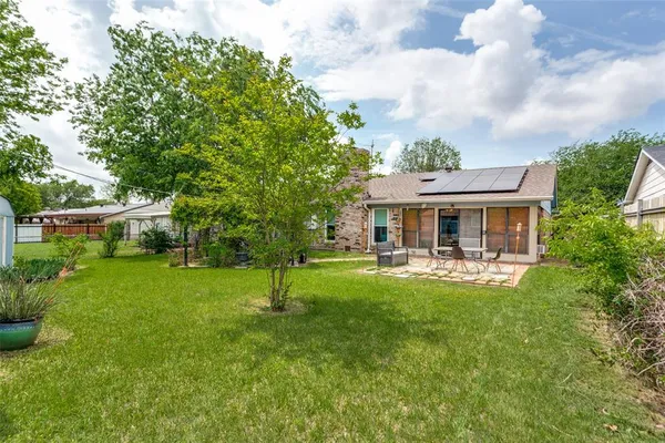 a front view of a house with garden and trees