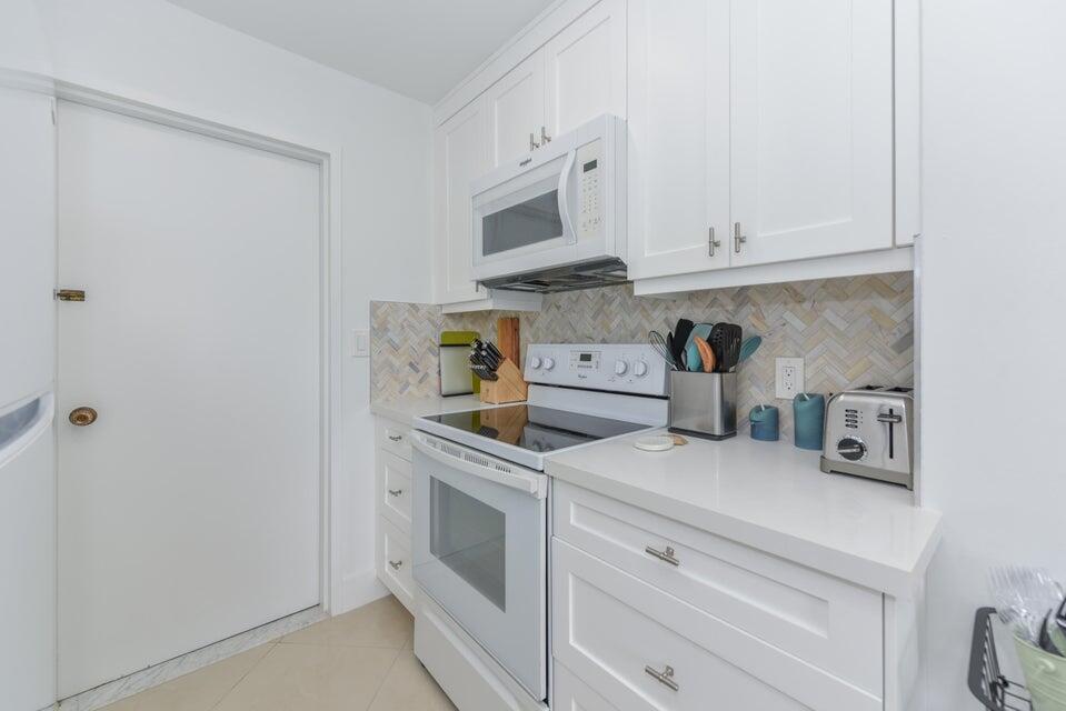 2860 South Ocean Boulevard, Unit 202 Palm Beach, FL 33480 - Photo 11 of 33 a kitchen with stainless steel appliances granite countertop white cabinets and a stove