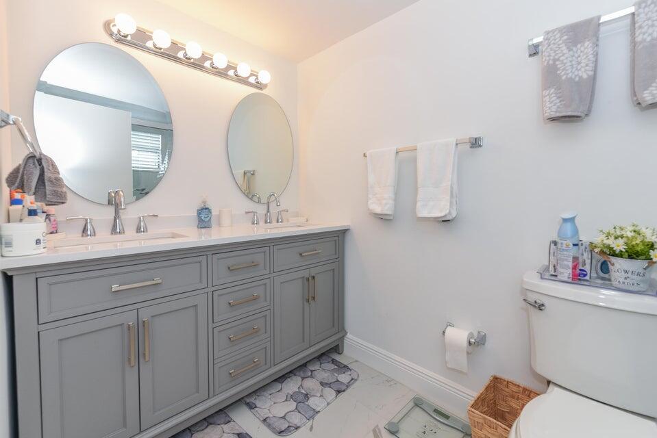 2860 South Ocean Boulevard, Unit 202 Palm Beach, FL 33480 - Photo 16 of 33 a bathroom with a toilet sink and mirror