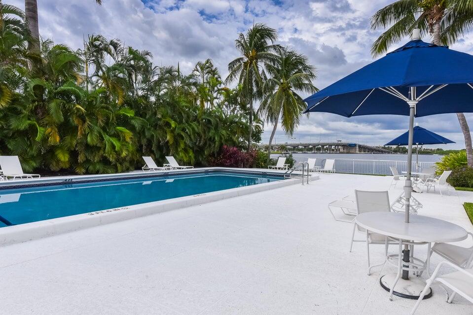 2860 South Ocean Boulevard, Unit 202 Palm Beach, FL 33480 - Photo 24 of 33 a view of a patio with table and chairs under an umbrella