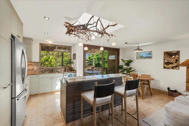 a kitchen with a table chairs refrigerator and cabinets
