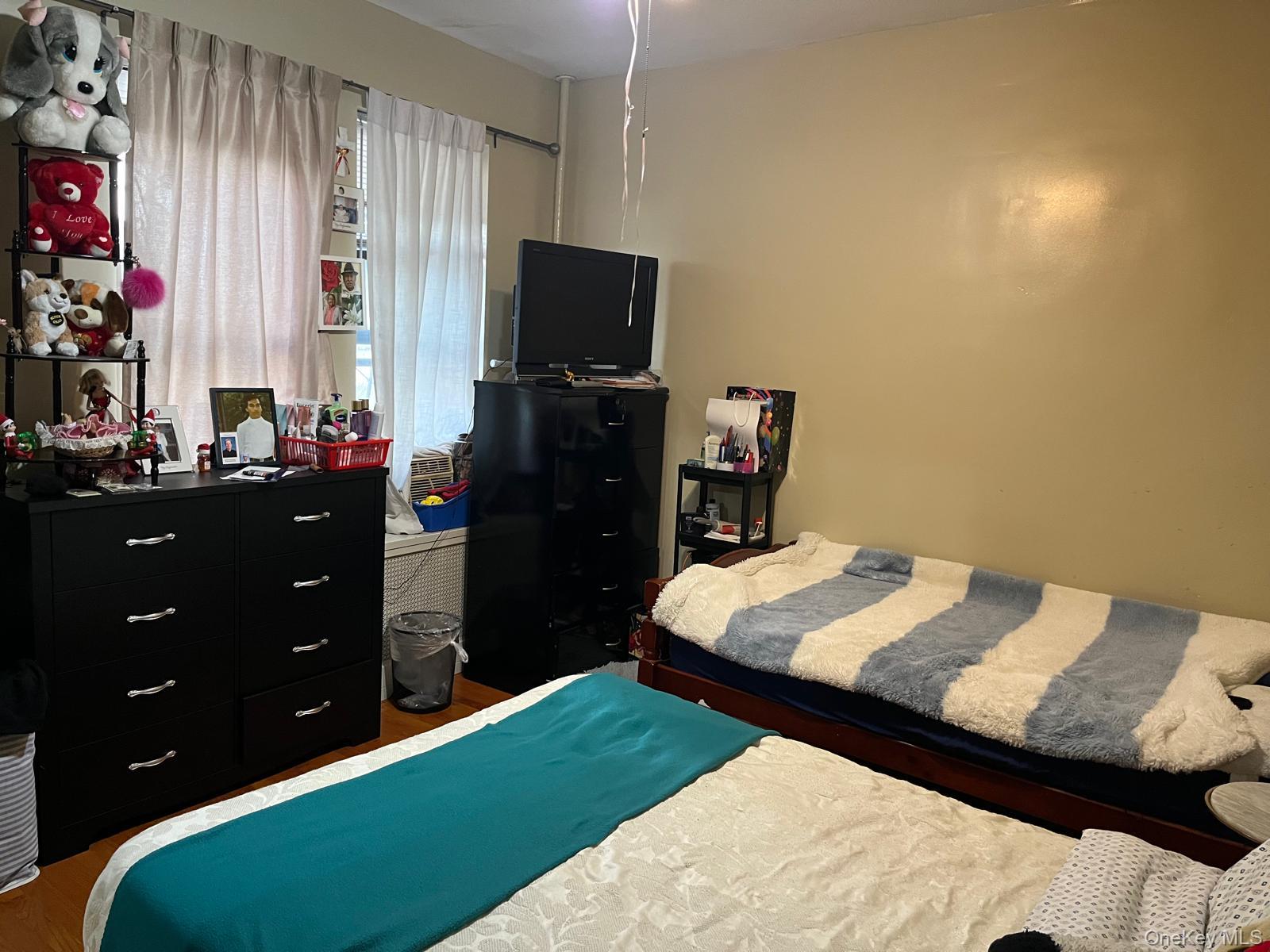 40-36 100th Street Queens, NY 11368 - Photo 9 of 11 a bed room with a bed and a television