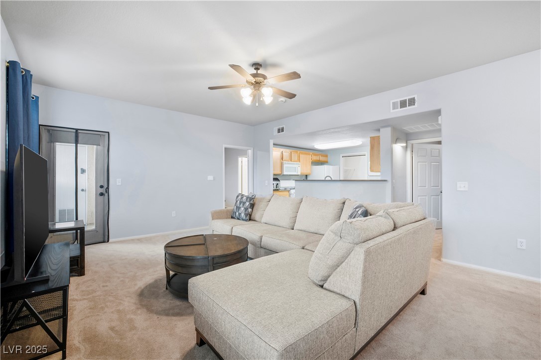 10001 Peace Way, Unit 1264 Las Vegas, NV 89147 - Photo 2 of 27 Living area with light colored carpet and a ceiling fan