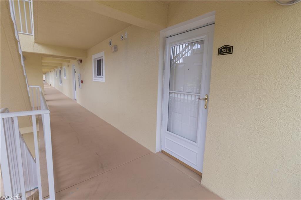 8234 Key Royal Circle, Unit 521 Naples, FL 34119 - Photo 14 of 19 a view of a hallway to rooms and stairs