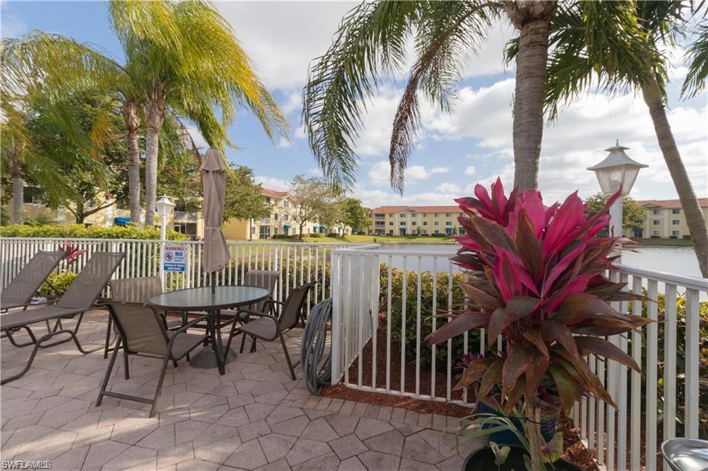 8234 Key Royal Circle, Unit 521 Naples, FL 34119 - Photo 17 of 19 a view of a chairs and table in patio with swimming pool