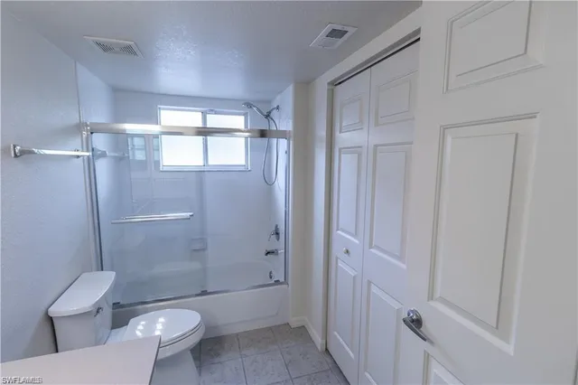 a bathroom with a granite countertop toilet a sink and shower