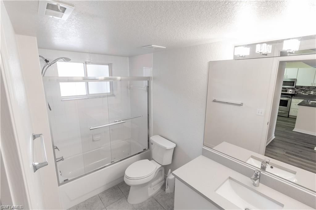 8234 Key Royal Circle, Unit 521 Naples, FL 34119 - Photo 8 of 19 a white toilet sitting next to a bathroom sink