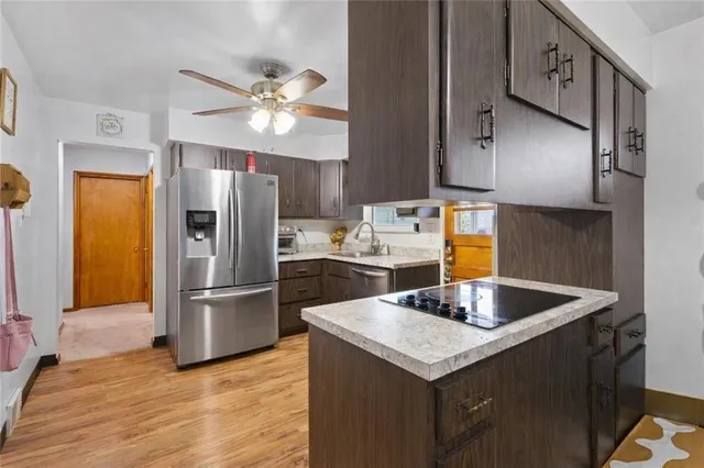 a kitchen with kitchen island granite countertop a sink refrigerator and microwave