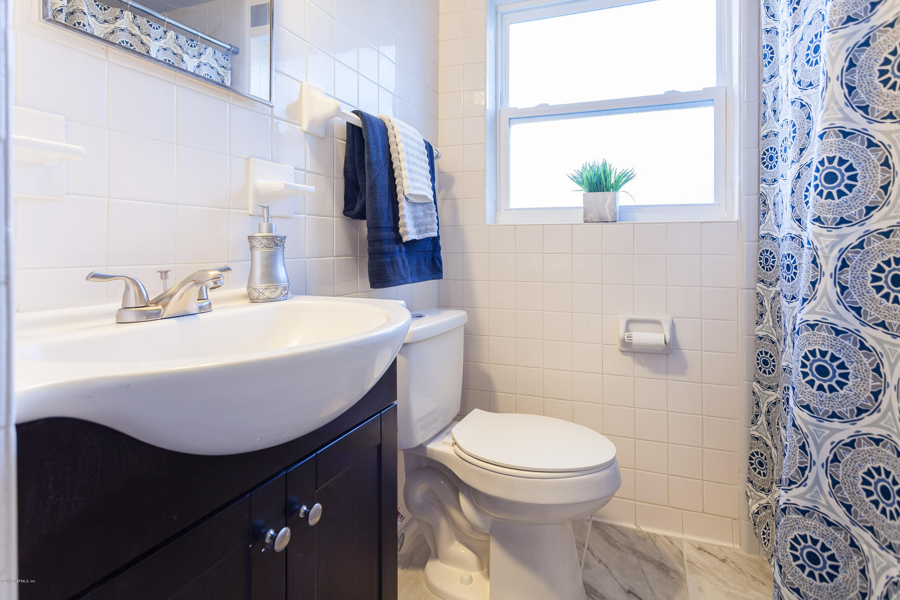 4230 Springwood Road Jacksonville, FL 32207 - Photo 15 of 20 a bathroom with a sink a toilet and a mirror