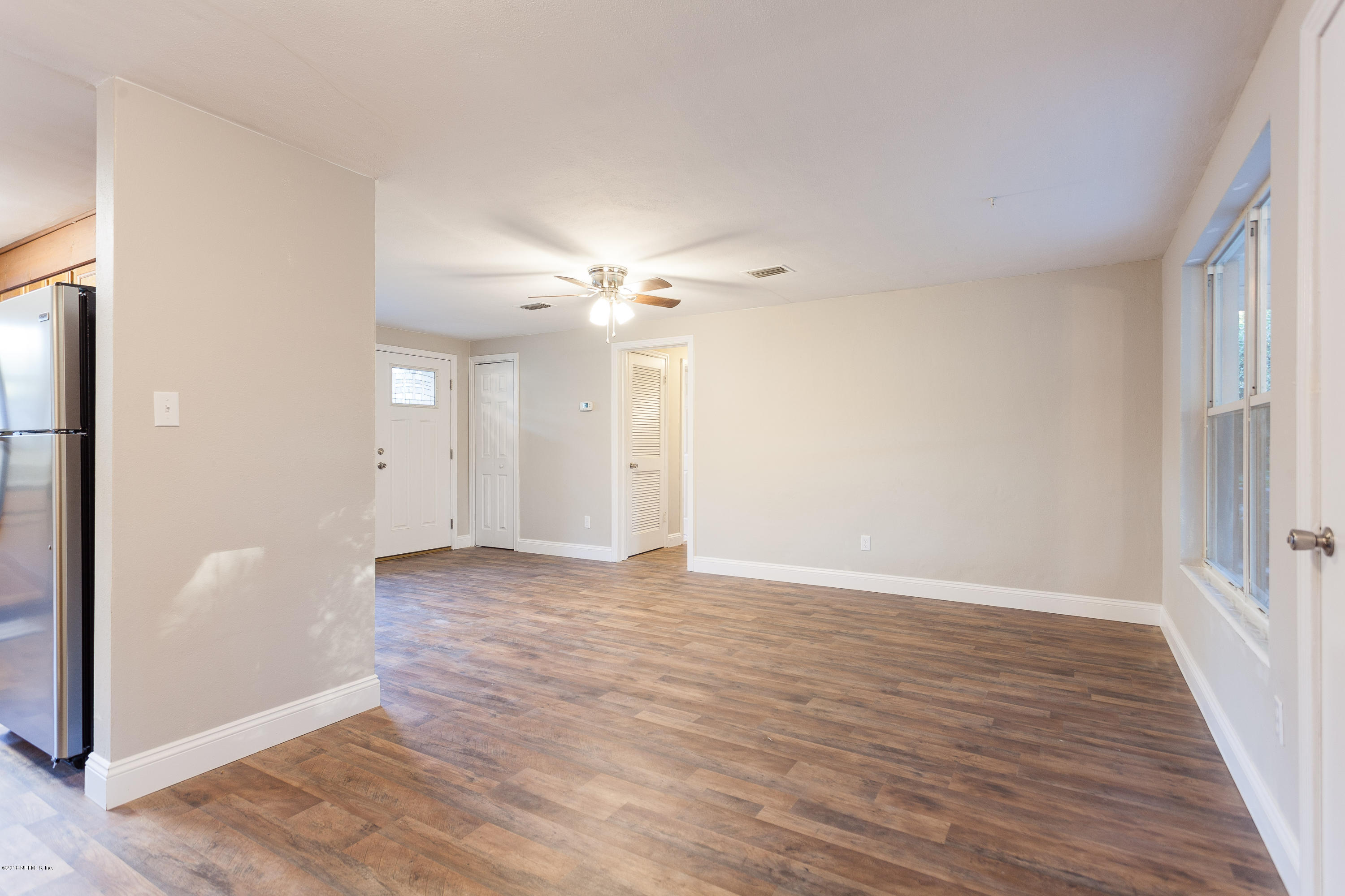 4230 Springwood Road Jacksonville, FL 32207 - Photo 3 of 20 an empty room with wooden floor and mirror