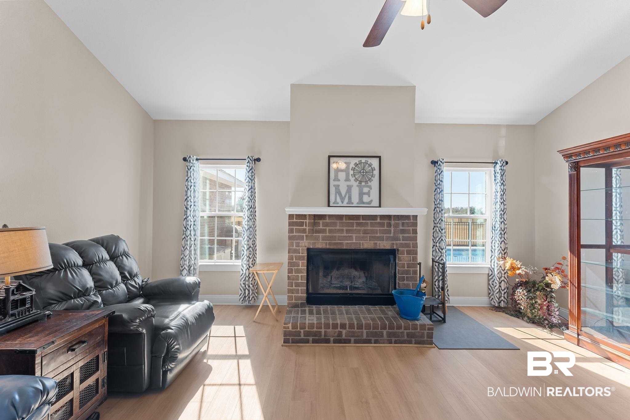 28980 Comstock Road Elberta, AL 36530 - Photo 6 of 38 Living area with light wood-style floors, a brick fireplace, and a ceiling fan