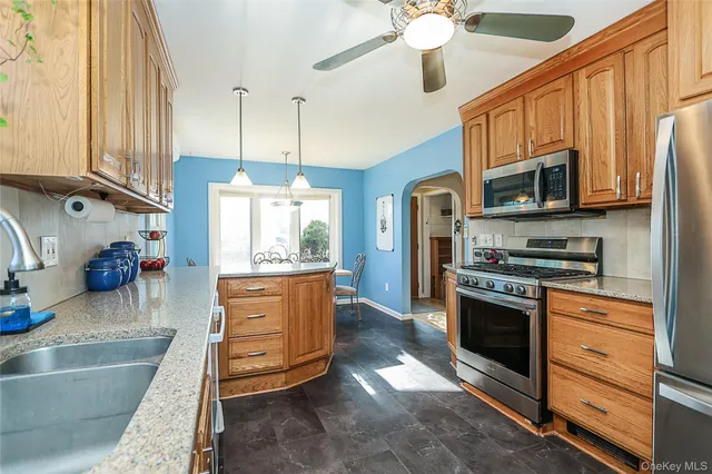 a kitchen with stainless steel appliances granite countertop a stove a sink and a refrigerator
