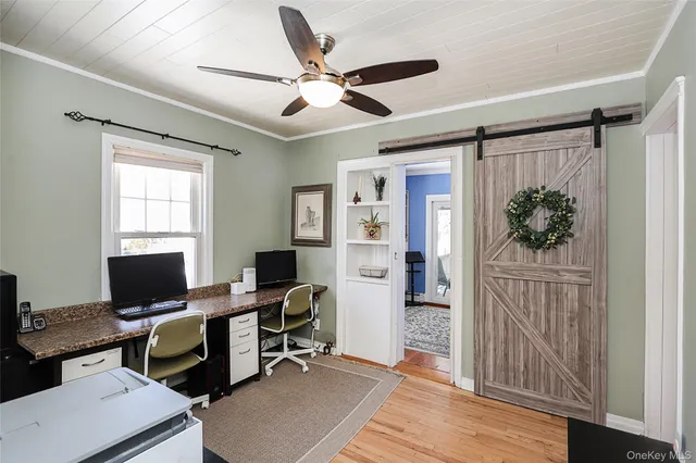 a view of a workspace with furniture and a window