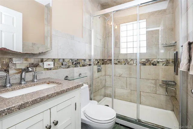 a bathroom with a granite countertop sink a mirror and a shower