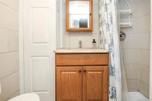 a bathroom with a granite countertop sink toilet and mirror