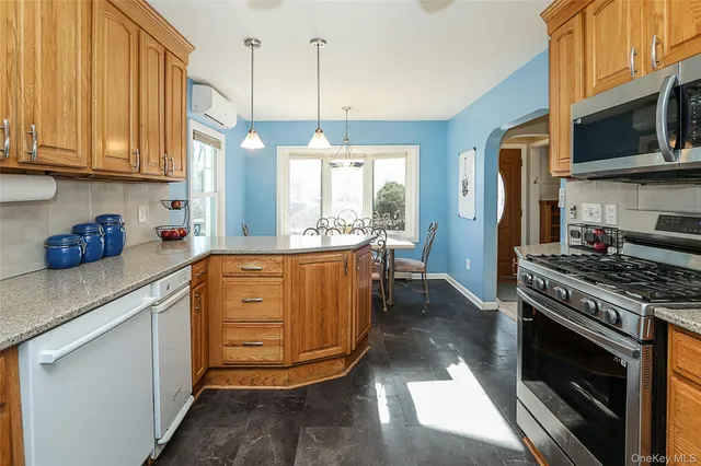 a kitchen with stainless steel appliances granite countertop a stove a sink and a refrigerator