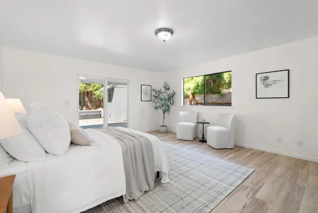 a bedroom with a large bed and a potted plant