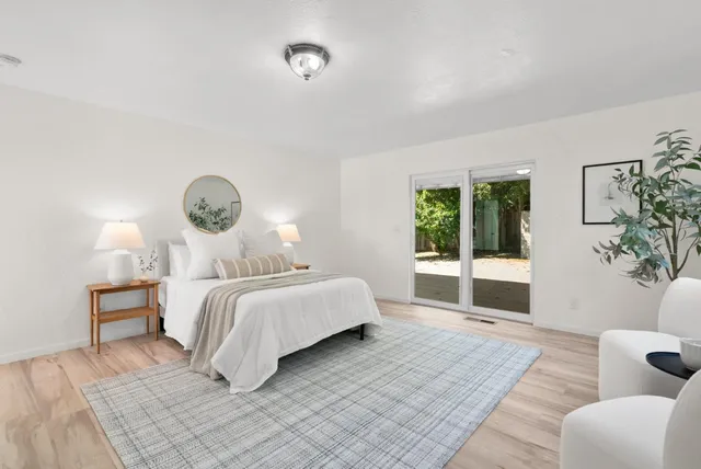 a bedroom with a large bed and a potted plant