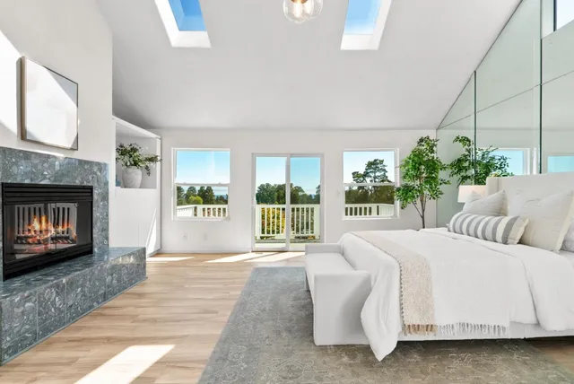 a bedroom with a bed a fireplace and a large window