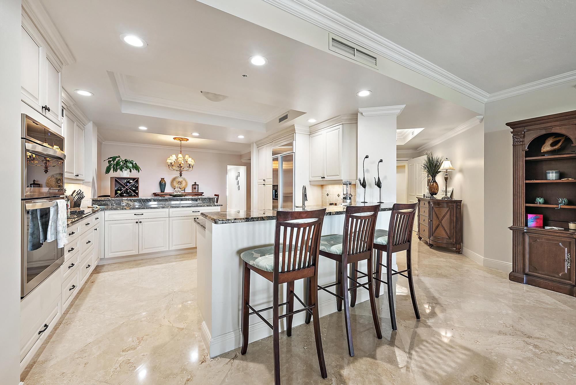 500 Highway 1, Unit 402 Jupiter, FL 33477 - Photo 15 of 38 a kitchen with stainless steel appliances kitchen island granite countertop a table chairs sink and cabinets