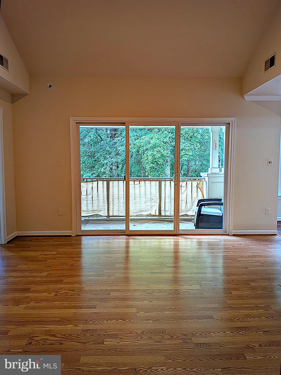 109 Timberbrook Lane, Unit 301 Gaithersburg, MD 20878 - Photo 4 of 22 a view of empty room with wooden floor and floor to ceiling window