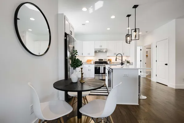 a kitchen with kitchen island a dining table chairs and a sink
