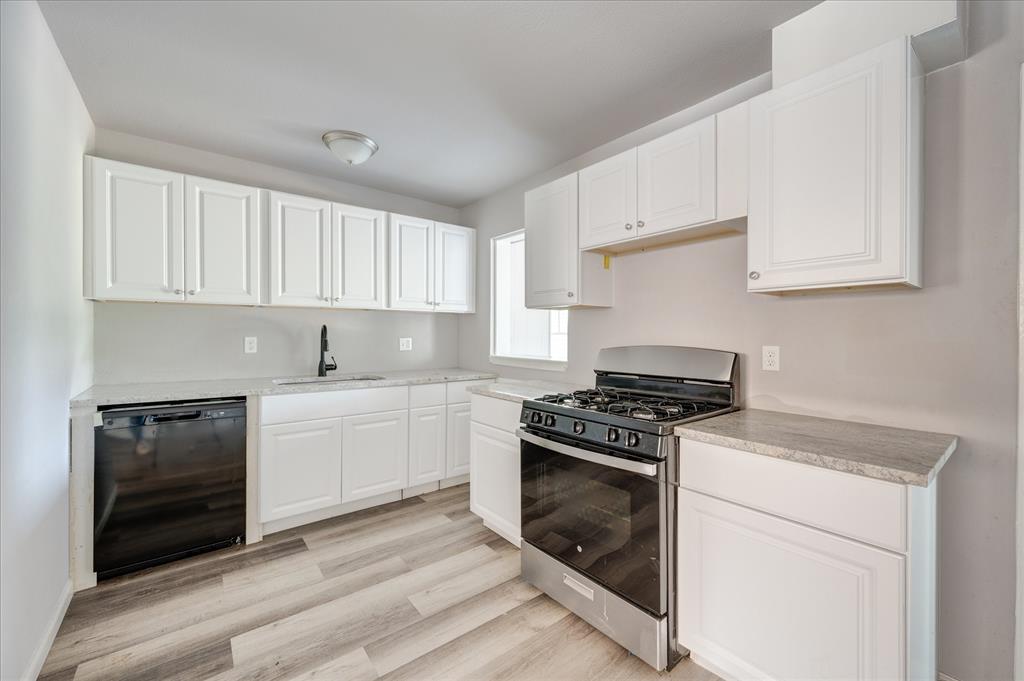 1902 Alan-A-Dale Road Arlington, TX 76013 - Photo 8 of 28 a kitchen with cabinets stainless steel appliances and wooden floor