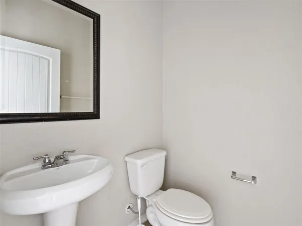 a bathroom with a toilet a sink and mirror