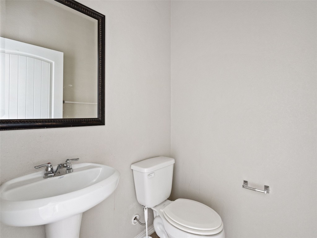 7633 Rio Pass Austin, TX 78724 - Photo 10 of 23 Half bathroom featuring toilet and a sink