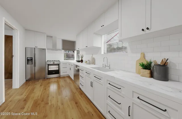 a kitchen with white cabinets and stainless steel appliances