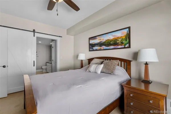 a bedroom with a bed and a lamp on dresser