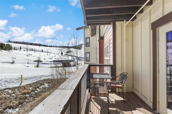 a balcony with wooden floor and outdoor seating