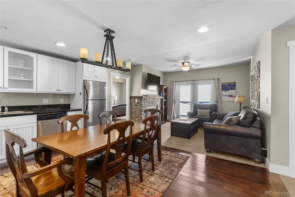 a view of a dining room with furniture a kitchen and chandelier