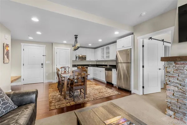 a kitchen with stainless steel appliances kitchen island granite countertop a refrigerator and a dining table