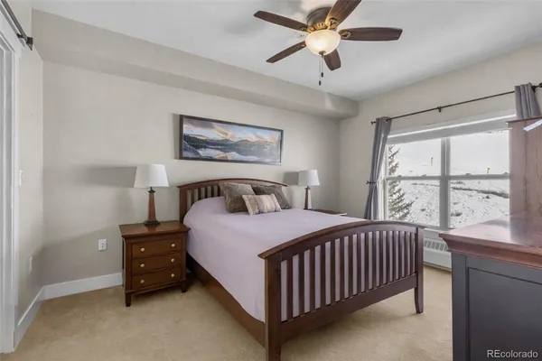 a bedroom with a bed and a large window