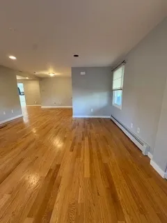 a view of a room with wooden floor and window