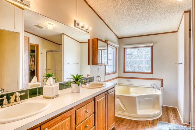 a bathroom with a granite countertop sink mirror and a bathtub
