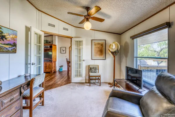 a living room with furniture a ceiling fan and a window