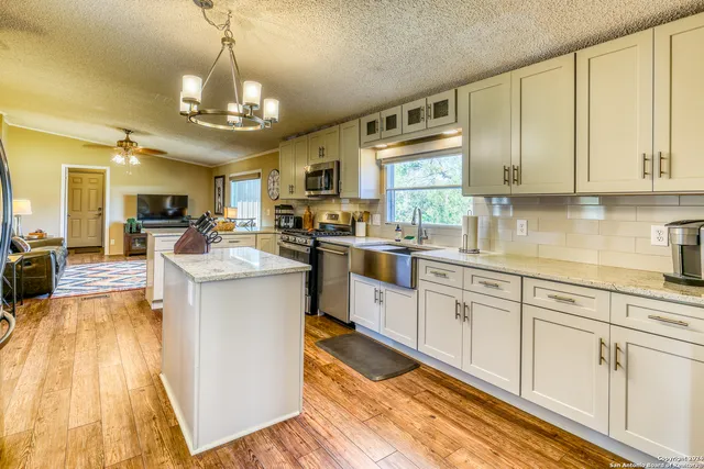 a kitchen with cabinets a sink and appliances