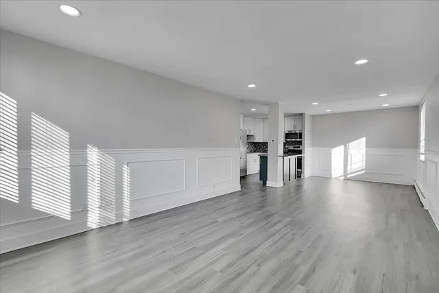 a view of empty room with wooden floor