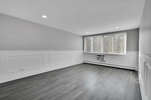 a kitchen with stainless steel appliances wooden floors and white cabinets