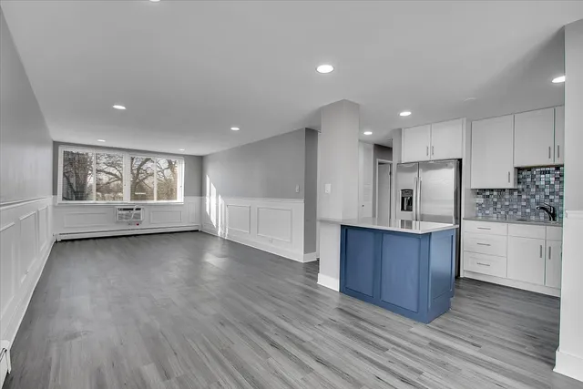 a kitchen with a refrigerator a sink and white cabinets