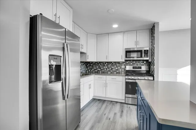 a kitchen with stainless steel appliances a refrigerator sink and microwave