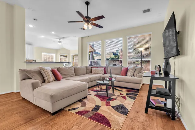 a living room with furniture flat screen tv and a large window