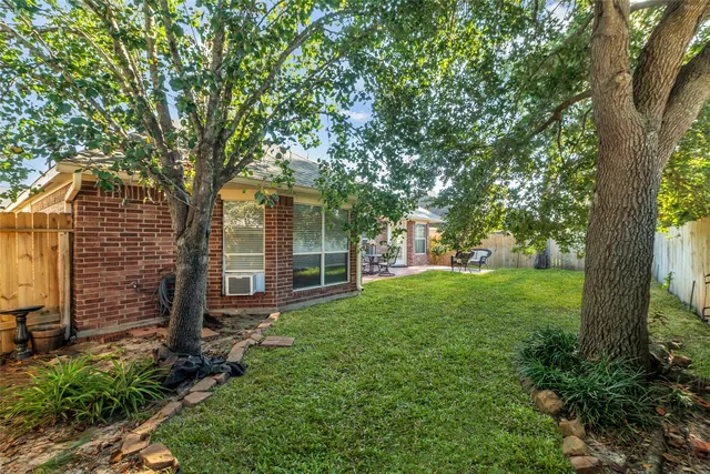 a view of a yard in front of a house with large trees